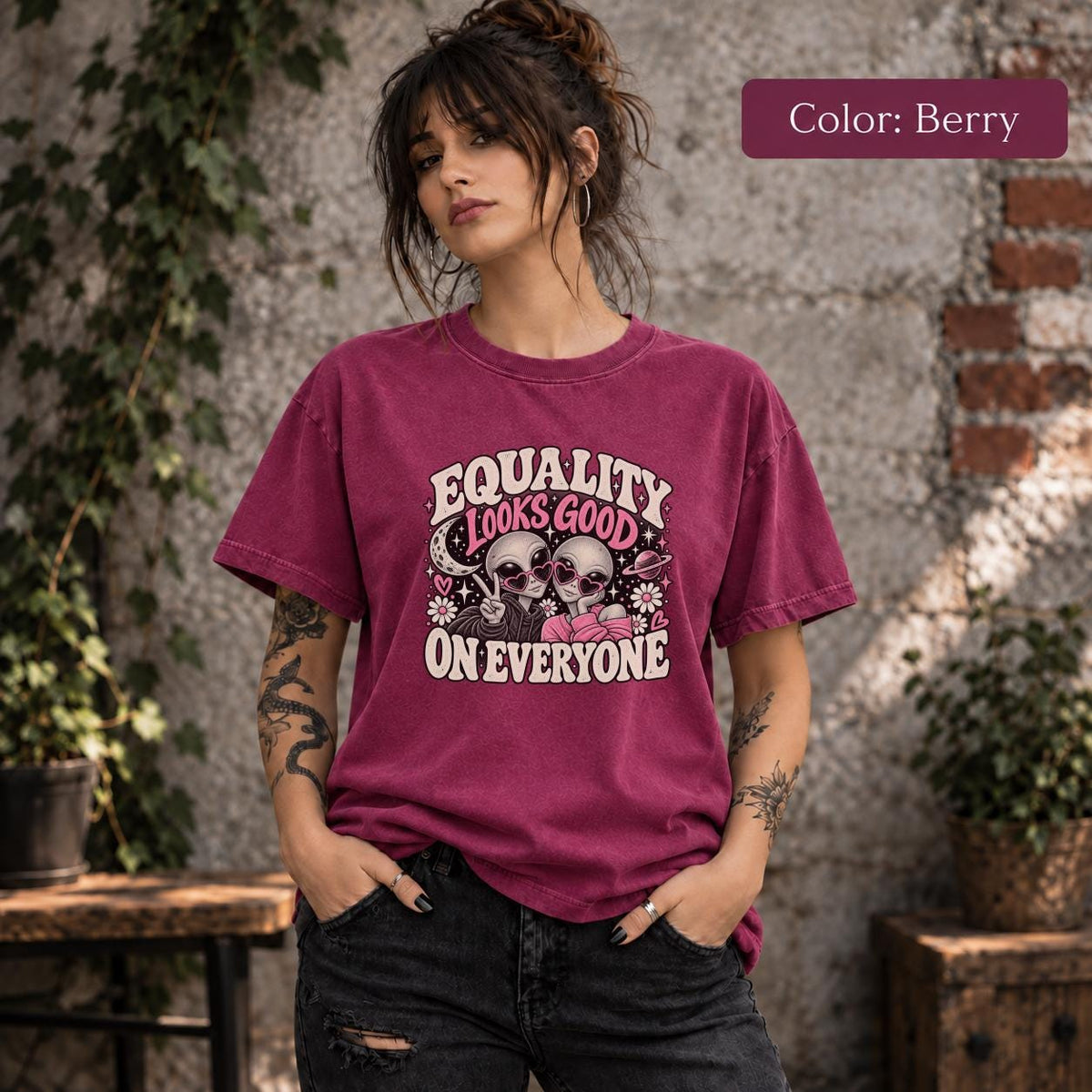 Color Berry shirt featuring the retro equality artwork with two aliens, pink hearts, stars, and cream statement text.