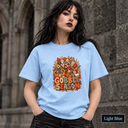 Light Blue unisex tee featuring the Thanksgiving artwork with sunflower, pumpkin, wheat, and berry details.