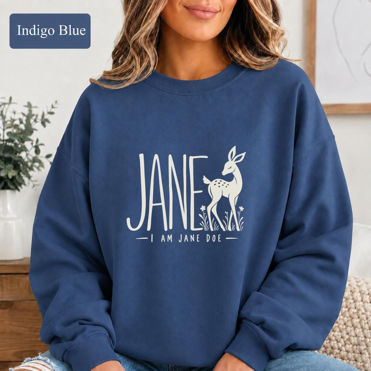 Indigo Blue crewneck featuring the “Jane — I Am Jane Doe” artwork with minimalist deer and floral details.