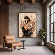 Vintage floral woman portrait displayed on a dark wall beside a tan leather accent chair. The romantic botanical artwork features delicate pink and white flowers, soft beige tones, and an elegant black dress.