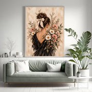 Romantic feminine art print displayed above a sage green sofa surrounded by houseplants. Blush wildflowers and an elegant black-dress portrait complement the soft, nature-inspired living room.