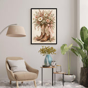 Framed country cottage wall art displayed above a comfortable cream accent chair beside a floor lamp and potted plant. The romantic floral cowboy boots design features a pink gingham bow and delicate wildflowers.