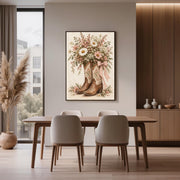 Western floral printable art displayed above a wooden dining table in a modern room with warm wood paneling. The artwork features rustic brown cowboy boots, delicate daisies, and soft blush-pink blossoms.