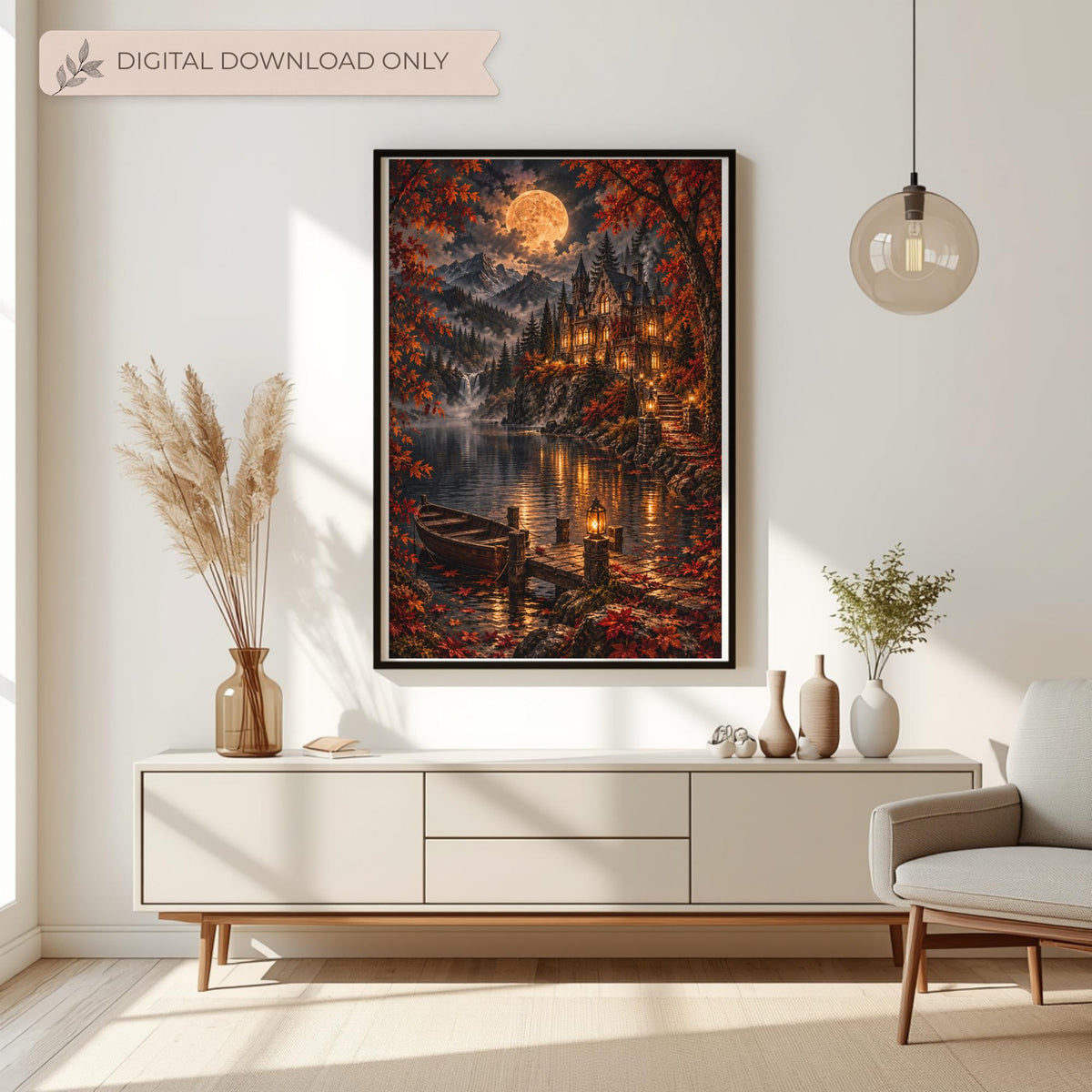 Framed gothic castle wall art displayed above a cream console table with dried botanical arrangements. The dark fantasy landscape features a moonlit Victorian manor, glowing windows, autumn leaves, and a peaceful mountain lake.