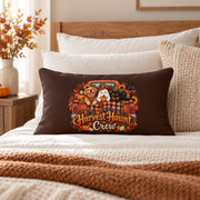 Brown Harvest Haunt Crew lumbar pillow centered on a cozy neutral bed with cream bedding, textured pillows, warm wood accents, and autumn decor.