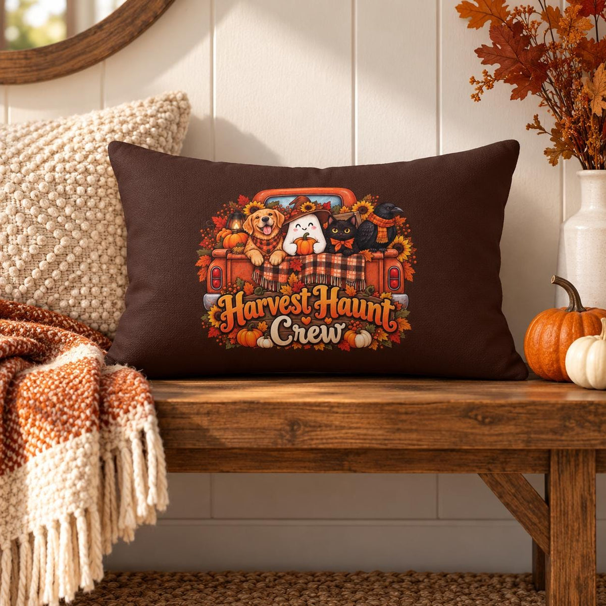 Harvest Haunt Crew lumbar pillow styled on a rustic wood bench with cream textured pillow, fall throw blanket, pumpkins, and autumn foliage.