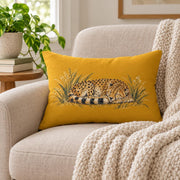 Mustard yellow rectangular lumbar pillow shown on a light neutral background with a sleeping spotted cheetah curled in painted grasses and wildflowers.