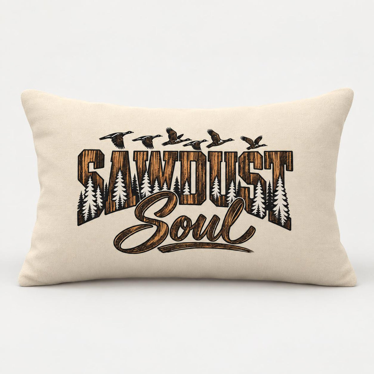 Cream rectangular Sawdust Soul lumbar pillow shown on a clean light background with bold rustic brown and black lettering, pine tree silhouettes, and flying birds.