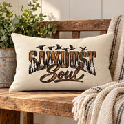 Sawdust Soul lumbar pillow styled on a rustic wood bench with neutral woven blanket, greenery, and warm farmhouse-inspired decor.