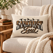Cream Sawdust Soul lumbar pillow displayed on a neutral armchair with chunky knit throw, books, warm wood accents, and soft natural light.