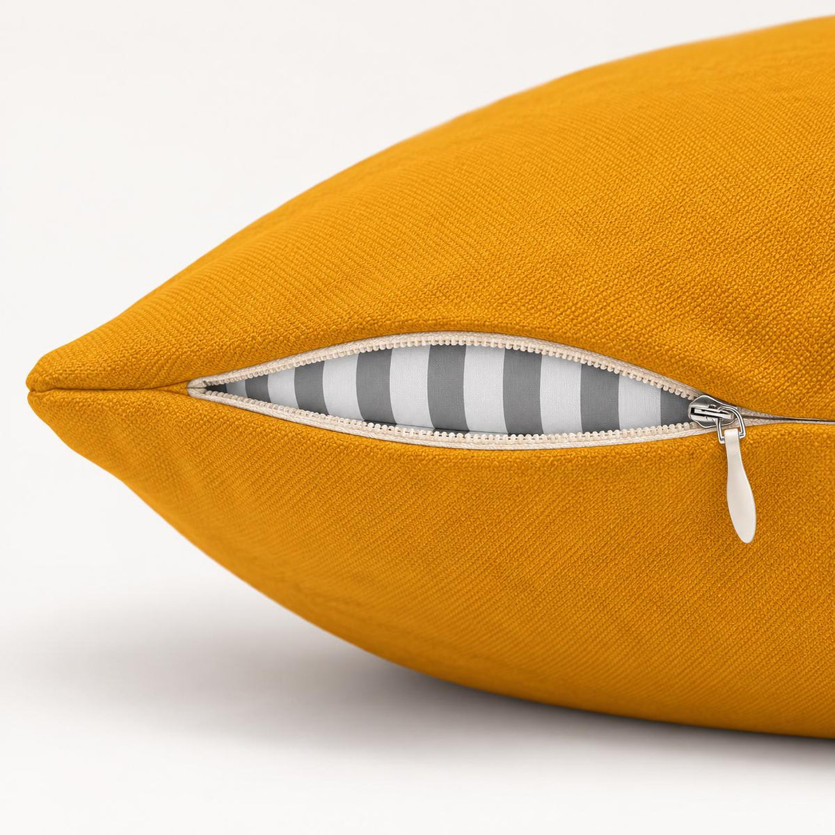 Close-up side view of the yellow pillow showing the zipper opening and inner cushion insert.
