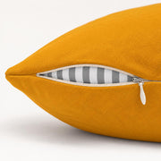 Close-up side view of the yellow pillow showing the zipper opening and inner cushion insert.