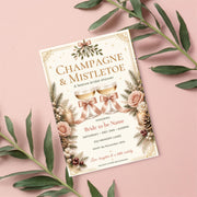 Vintage Christmas and Mistletoe party invitation displayed on a blush pink background with leafy green accents. The festive digital template features ornamental holiday typography, red berries, and greenery surrounding the invitation details.