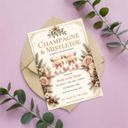 Vintage Christmas and Mistletoe invitation displayed on a blush pink background surrounded by eucalyptus leaves. The editable holiday template features elegant gold lettering, evergreen branches, red berries, and a warm cream background.