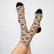Retro dog patterned socks modeled with feet raised against a clean white background. Features golden retrievers and other playful dogs wearing sunglasses, diner food illustrations, smiley faces, and contrasting black toes and heels.
