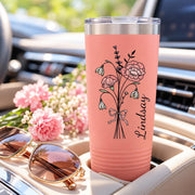 Coral tumbler showcasing the personalized botanical design with pink flowers, ribbon accent, and custom name beside the artwork.
