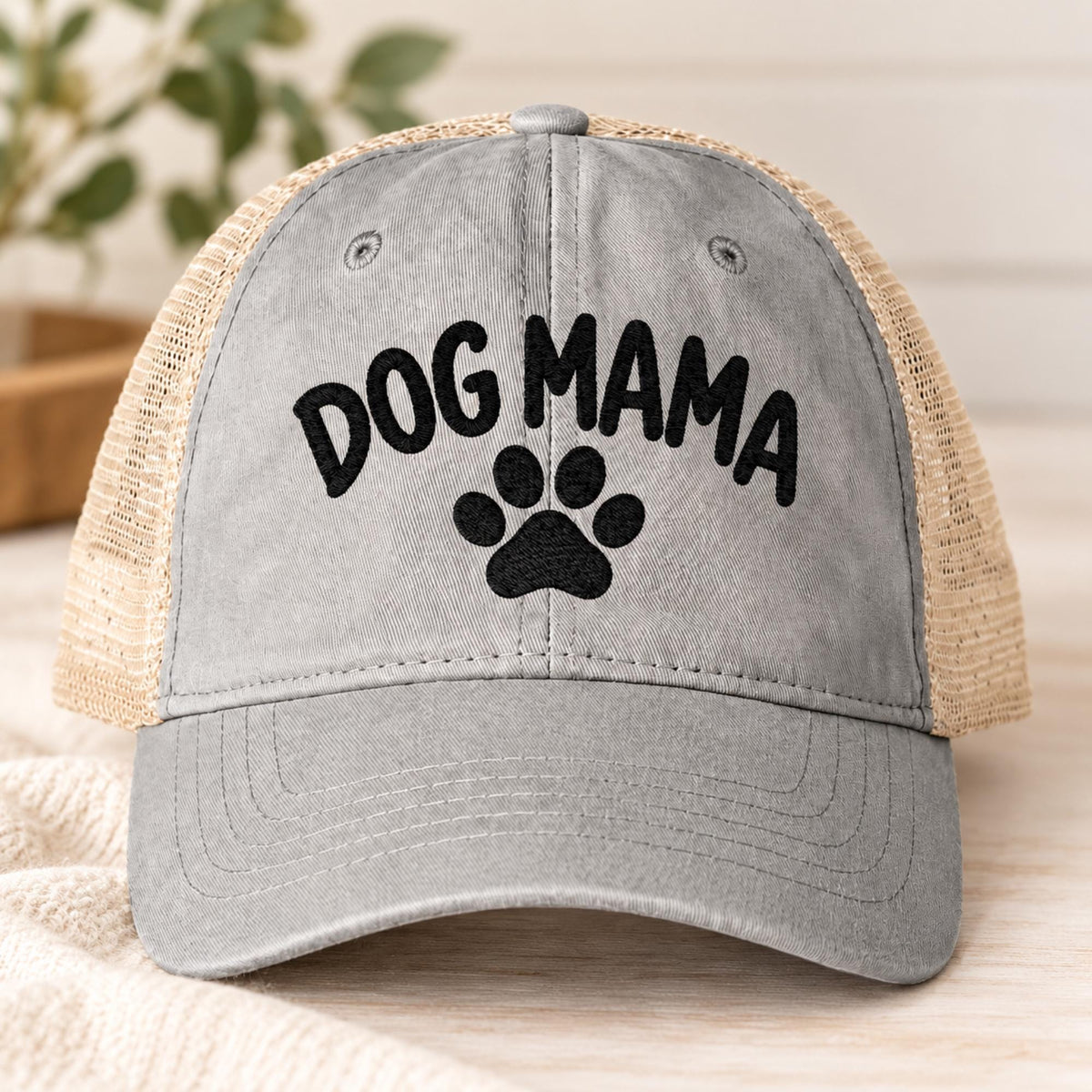 Light grey women’s mesh-back hat featuring the Dog Mama design with black embroidered lettering and paw graphic.