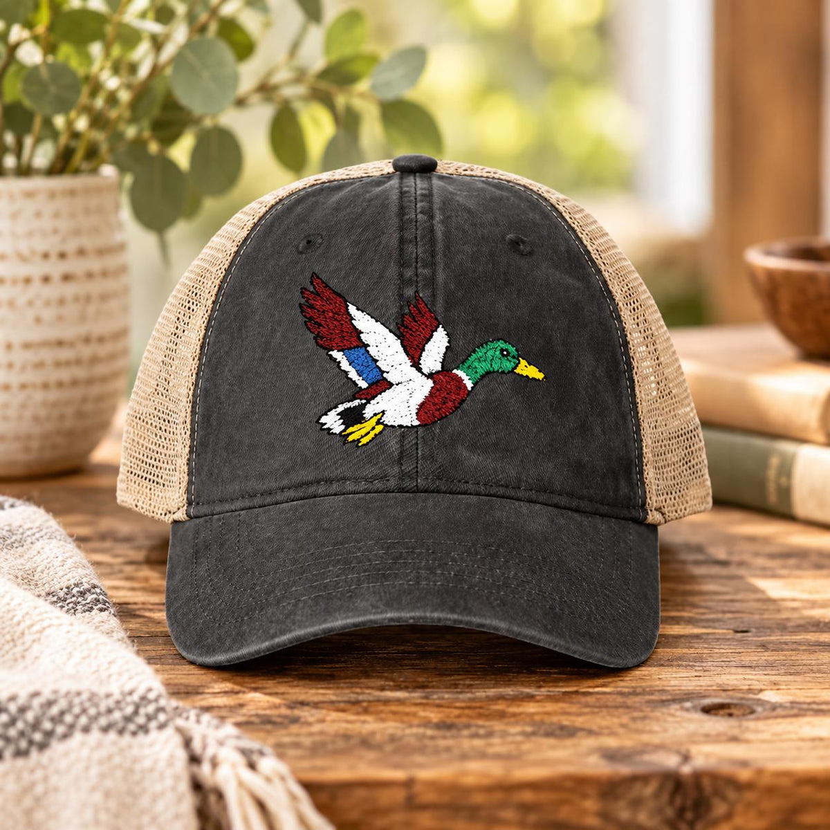 Black washed ponytail cap displaying the embroidered mallard design with tan mesh back and casual low-profile shape.