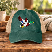 Jade green ponytail cap displaying the colorful embroidered duck design with washed fabric and tan mesh panels.