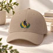 Khaki Flexfit hat showcasing the black bird embroidery with golden moon, leafy branches, and small star detail.