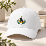 White Flexfit hat displaying the celestial raven embroidery with gold moon and botanical accents on the front panel.