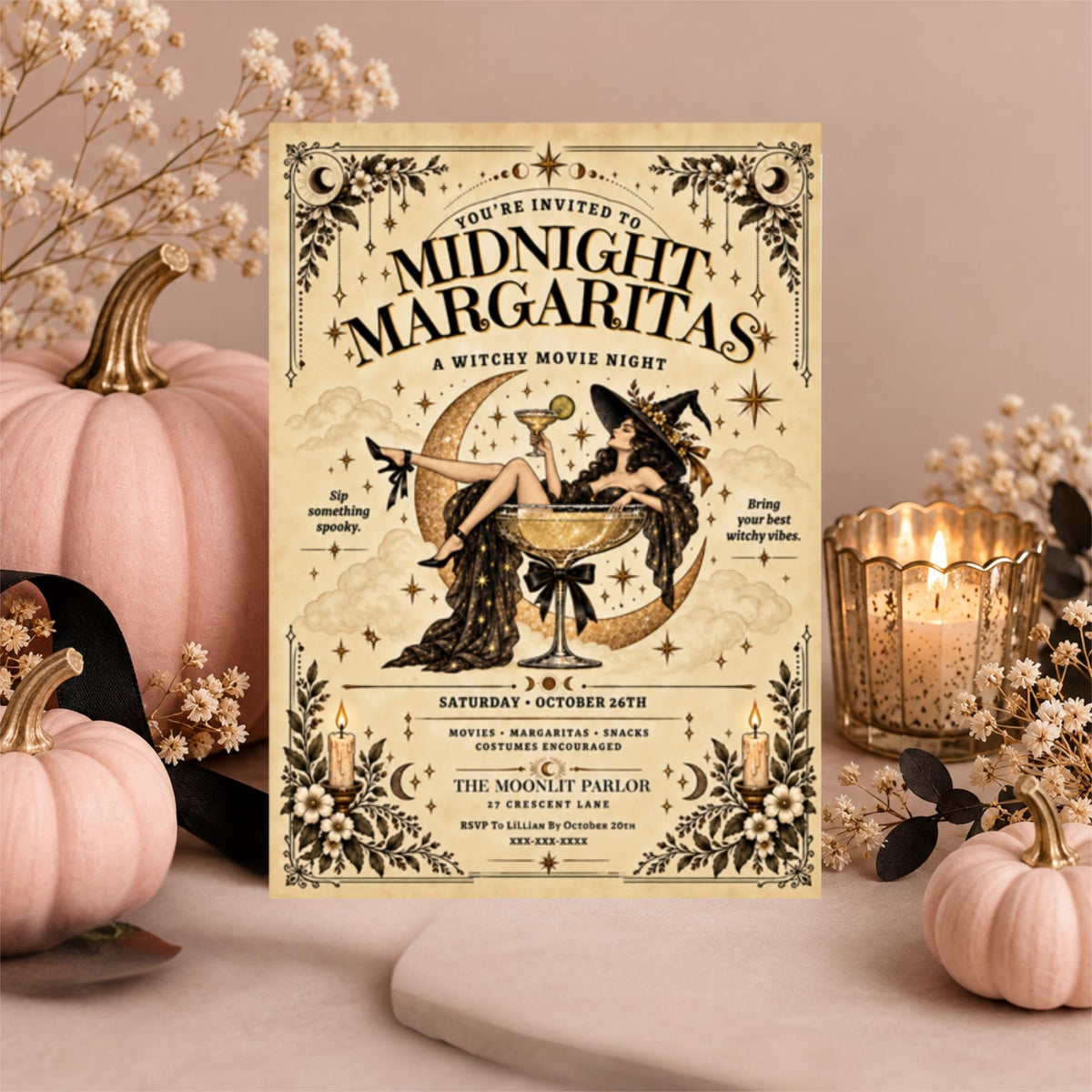 Editable Midnight Margaritas Halloween invitation displayed on a dusty pink background with pale pumpkins, dried flowers, and candlelight. The vintage witch illustration features Gothic lettering, celestial details, and a decorative cream background.