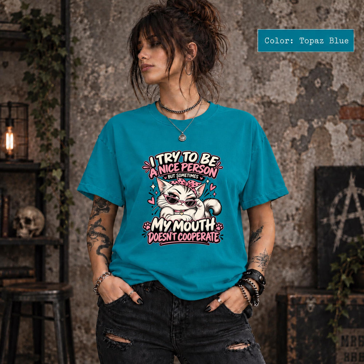 Topaz Blue Comfort Colors T-shirt displaying the sassy cat artwork with bold pink lettering and playful retro accents.