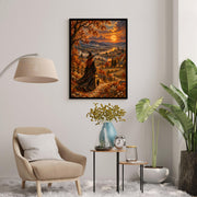 Framed autumn witch printable art resting on a rustic wooden cabinet beside a potted green plant. The magical painting features a black cat, pumpkins, distant mountains, and warm moonlight illuminating an autumn landscape.