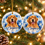 Two matching round ceramic dog ornaments hanging on a Christmas tree, featuring a golden retriever portrait, blue watercolor artwork, gold detailing, and personalized name Cooper with the year 2015.