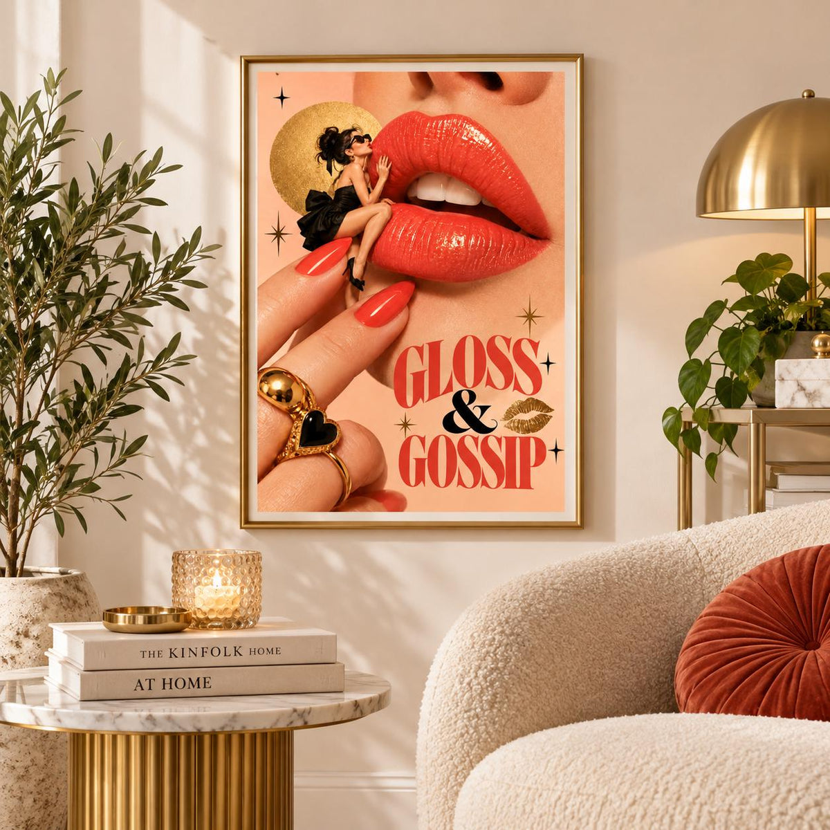 Sassy beauty wall art displayed above a cream boucle chair beside a wooden side table and leafy greenery. The framed Gloss and Gossip poster features dramatic red lips, a stylish woman wearing sunglasses, and vintage-inspired gold details.