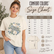 Comfort Colors size chart showing unisex shirt measurements, fit guidance, garment details, and model reference for the floral graphic tee.