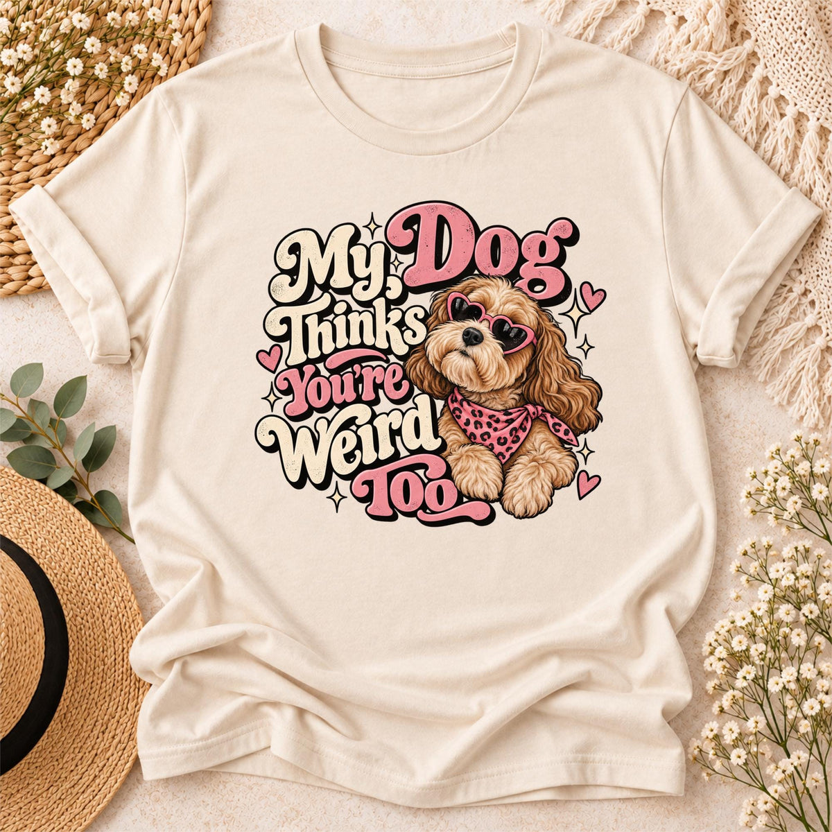 Styled cream T-shirt displaying My Dog Thinks You're Weird Too printable artwork with pink hearts, fluffy dog illustration, and retro typography.