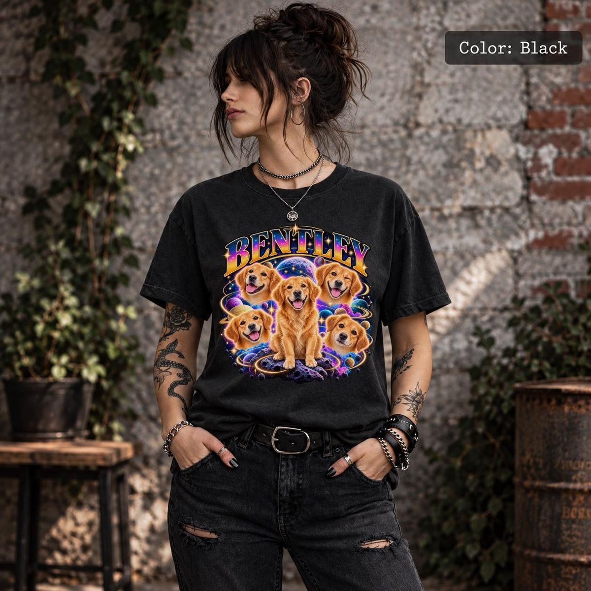 Woman wearing a black custom pet portrait tee featuring a golden dog illustrated in multiple poses against a colorful solar system background.