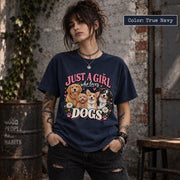 Woman wearing a true navy blue dog mom graphic T-shirt featuring four adorable dog portraits, pink lettering, colorful flowers and decorative paw prints.