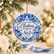 Personalized First Christmas Married ornament hanging from a Christmas tree with warm glowing lights, featuring vintage blue porcelain artwork, initials, snowflakes and wedding details.
