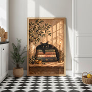 Vintage black cat poster displayed in a wooden frame on a console table near a sunlit wall and leafy plant. The botanical illustration adds warm golden tones to a neutral entryway.