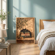 Vintage botanical wall art featuring a black cat resting on antique books, surrounded by olive branches and warm golden light. Framed printable poster displayed on a wooden bedside table in a cozy, neutral bedroom.