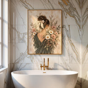 Floral woman printable displayed above a freestanding bathtub in a bright bathroom. The artwork features an elegant updo with a cream bow, a black dress, and soft pink botanical flowers.