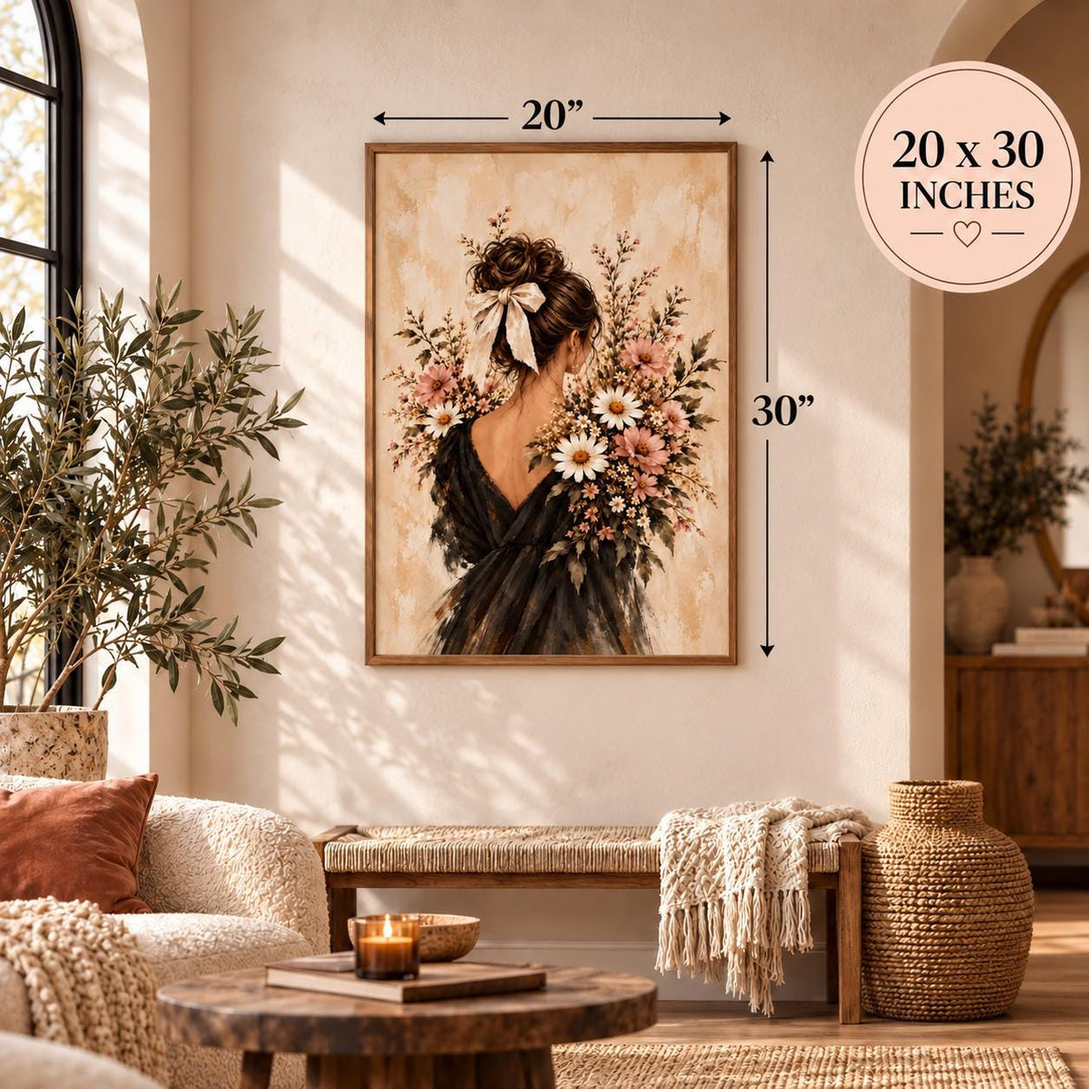 Framed floral woman wall art displayed in a warm boho living room with neutral furnishings and natural wood accents. The romantic botanical poster features a brunette woman wearing an ivory hair bow and flowing black dress, surrounded by pink wildflowers and white daisies.