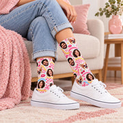 Personalized picture socks paired with cuffed blue jeans and white sneakers in a bright living room. Fun photo collage features custom faces, a corgi, pink checkerboard details, cherries, and colorful retro patterns.
