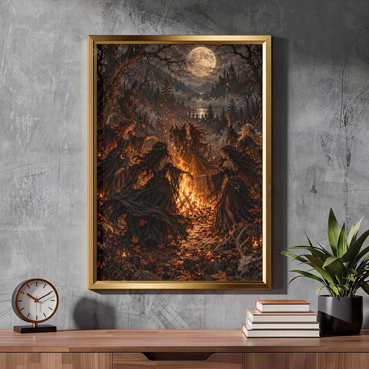 Framed dark witchcraft-inspired artwork resting on a rustic wooden cabinet against a textured wall. The illustration features five witches dancing around a bonfire beneath a glowing moon.
