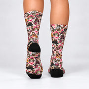 Rear view of pink bow cat crew socks showing the all-over feline pattern and contrasting black heels. Features cats, leopard print accessories, pink hearts, coffee illustrations, and colorful retro decorations.