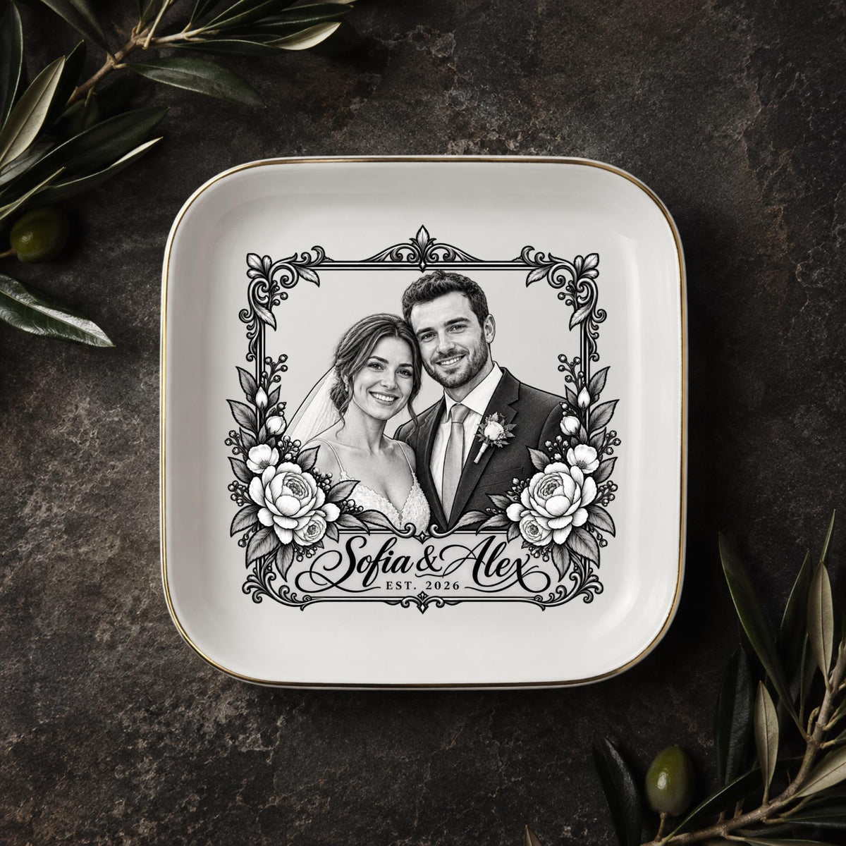 Personalized couple jewelry dish displayed on a dark elegant surface with greenery, featuring a custom wedding portrait and ornate vintage-style border.