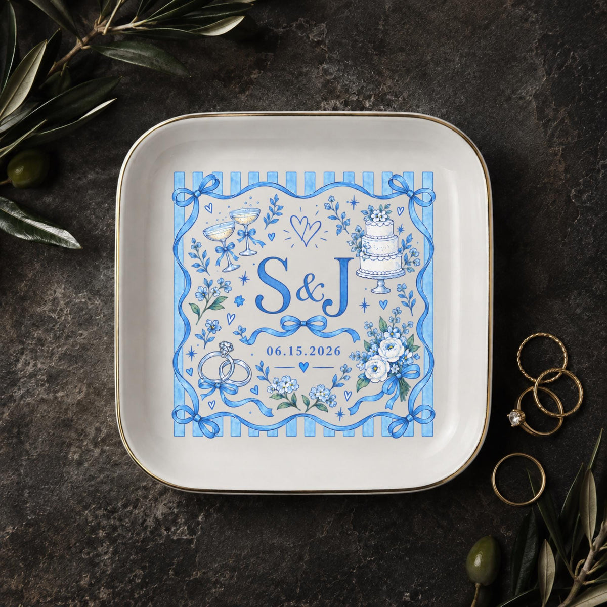 Personalized wedding jewelry dish featuring blue floral artwork, ribbon details, custom initials S and J, and a wedding date on a square ceramic dish with gold trim.