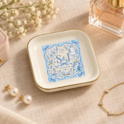 Custom ceramic jewelry dish displayed with perfume and delicate accessories on a warm neutral surface, featuring a blue personalized wedding motif and gold trim.