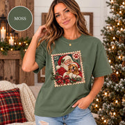 Moss Comfort Colors shirt featuring the personalized holiday graphic with Santa holding a dog, festive greenery, snowy trees, and classic Christmas colors.