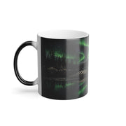 Printify product mockup of the loon colour-changing mug with the handle on the left, showing green northern lights reflected on a dark lake