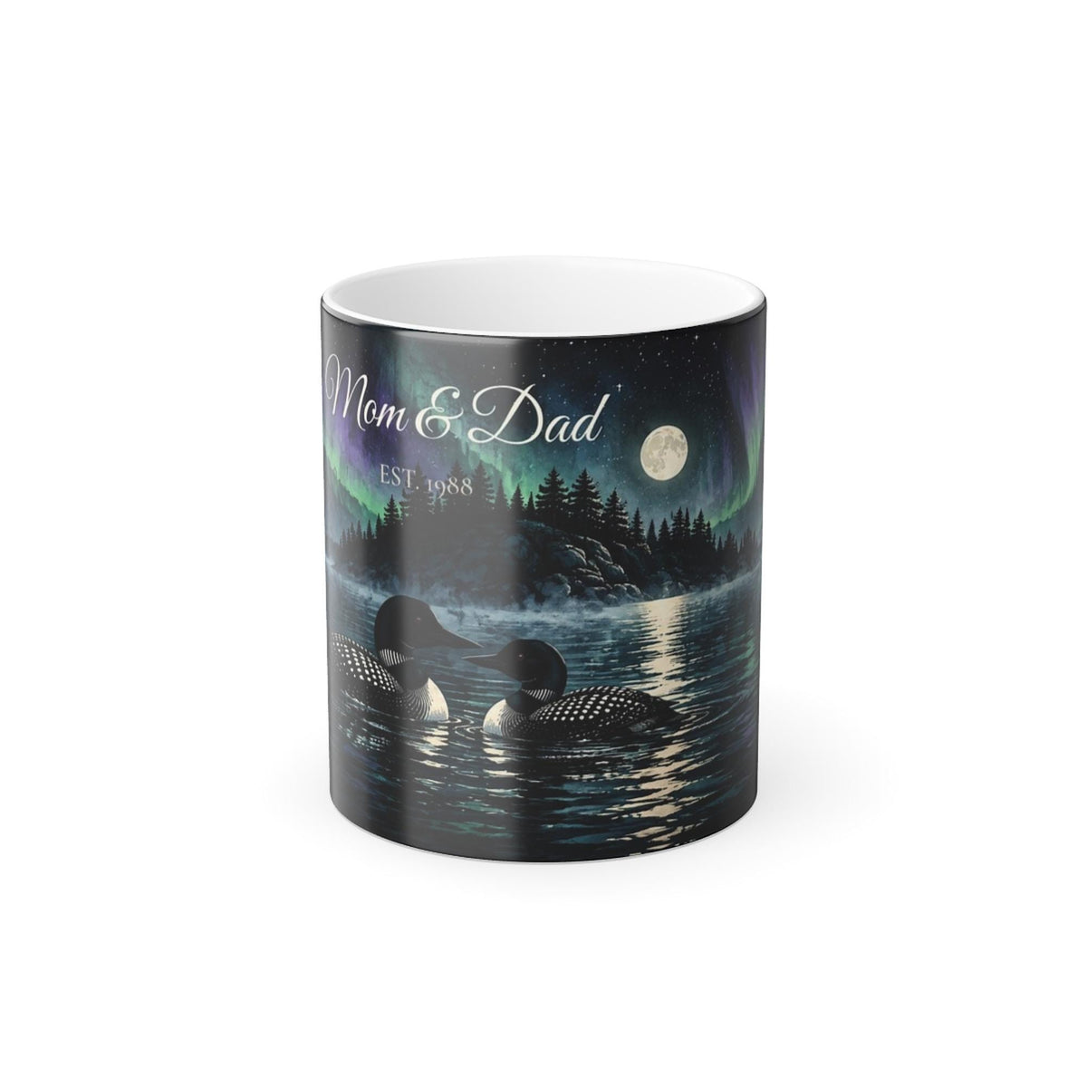 Printify product mockup of the 11 oz black colour-changing mug printed with two loons on a lake under the northern lights and the example names Mom and Dad, Est. 1988, in the sky