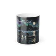 Printify product mockup of the 11 oz black colour-changing mug printed with two loons on a lake under the northern lights and the example names Mom and Dad, Est. 1988, in the sky